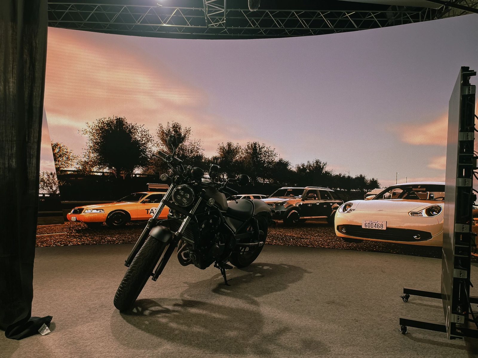 Motorcycle and sports cars shot in front of the curved LED wall